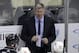 Calgary Flames head coach Bill Peters stands behind his bench during the third period of an NHL hockey game against the Pittsburgh Penguins in Pittsburgh, Monday, Nov. 25, 2019. The Penguins won in overtime 3-2. (AP Photo/Gene J. Puskar)