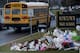 A school bus passes a makeshift memorial to the victims of the Sandy Hook Elementary School shooting as it takes students to Newtown High School December 18, 2012 in Newtown, Connecticut. Students in Newtown, excluding Sandy Hook Elementary School, return to school for the first time since last Friday's shooting at Sandy Hook which took the live of 20 students and 6 adults. AFP PHOTO/Brendan SMIALOWSKI / AFP / BRENDAN SMIALOWSKI (Photo credit should read BRENDAN SMIALOWSKI/AFP via Getty Images)