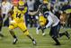 Kent State quarterback Dustin Crum (14) carries the ball as Utah State safety Troy Lefeged Jr. (3) defends during the first half of the Frisco Bowl NCAA college football game Friday, Dec. 20, 2019, in Frisco, Texas. (AP Photo/Brandon Wade)