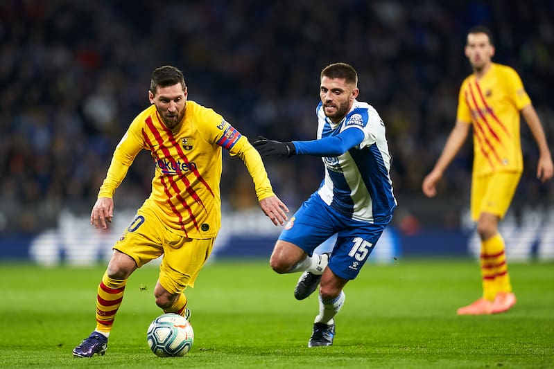 BARCELONA, SPAIN - JANUARY 04: David Lopez of RCD Espanyol competes for the ball with Lionel Messi of FC Barcelona during the Liga match between RCD Espanyol and FC Barcelona at RCDE Stadium on January 04, 2020 in Barcelona, Spain. (Photo by Quality Sport Images/Getty Images)