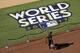 A worker places a barrier around the World Series baseball logo at Minute Maid Park as preparation are made for Game 3, Thursday, Oct. 26, 2017, in Houston, Texas. The Los Angeles Dodgers will face the Houston Astros Friday. (AP Photo/Eric Gay)