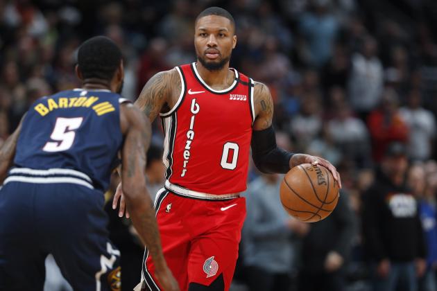 Portland Trail Blazers guard Damian Lillard, back, looks to pass the ball as Denver Nuggets forward Will Barton drops back to defend in the first half of an NBA basketball game Tuesday, Feb. 4, 2020, in Denver. (AP Photo/David Zalubowski)