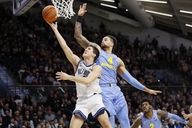 Villanova's Collin Gillespie, left, goes up for a shot past Marquette's Theo John during the second half of an NCAA college basketball game Wednesday, Feb. 12, 2020, in Villanova, Pa. (AP Photo/Matt Slocum)