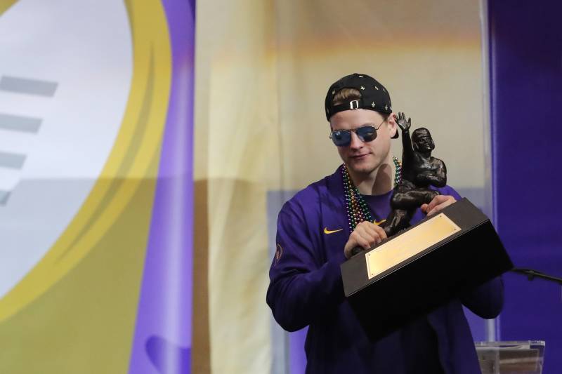 LSU quarterback Joe Burrow holds the Heisman Trophy that is being presented to the school during a celebration of their NCAA college football championship, Saturday, Jan. 18, 2020, on the LSU campus in Baton Rouge, La. (AP Photo/Gerald Herbert)