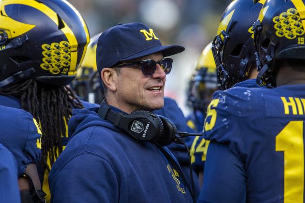Michigan head coach Jim Harbaugh huddles with his players on the field during a time out in the fourth quarter of an NCAA college football game against Michigan State in Ann Arbor, Mich., Saturday, Nov. 16, 2019. Michigan won 44-10. (AP Photo/Tony Ding)