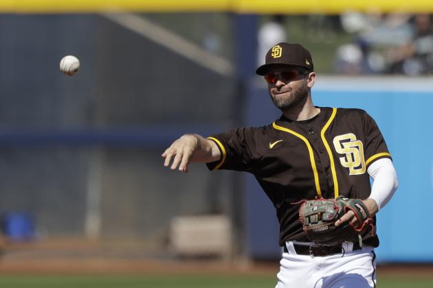 San Diego Padres second baseman Brian Dozier tosses a ball during a spring training baseball game against the Los Angeles Dodgers Monday, March 9, 2020, in Peoria, Ariz. (AP Photo/Elaine Thompson)