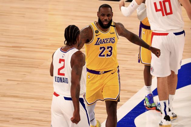 Los Angeles Lakers' LeBron James (23) talks with Los Angeles Clippers' Kawhi Leonard (2) during the first quarter of an NBA basketball game Thursday, July 30, 2020, in Lake Buena Vista, Fla. (Mike Ehrmann/Getty Images via AP, Pool)