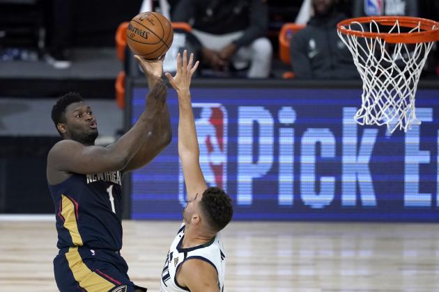 New Orleans Pelicans' Zion Williamson, left, shoots over Utah Jazz's Georges Niang during the first half of an NBA basketball game Thursday, July 30, 2020, in Lake Buena Vista, Fla. (AP Photo/Ashley Landis, Pool)