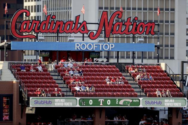 A few fans watch the action from seats across the street outside Busch Stadium as the St. Louis Cardinals and Pittsburgh Pirates play an opening day baseball game without fans in the stadium Friday, July 24, 2020, in St. Louis. (AP Photo/Jeff Roberson)
