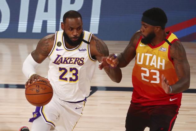 Los Angeles Lakers forward LeBron James, left, dribbles against Utah Jazz forward Royce O'Neale, right, during the first half of an NBA basketball game Monday, Aug. 3, 2020, in Lake Buena Vista, Fla. (Kim Klement/Pool Photo via AP)