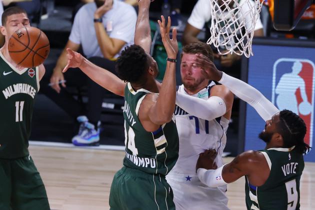 Dallas Mavericks' Luka Doncic passes away from Milwaukee Bucks' Giannis Antetokounmpo (34) and Wesley Matthews, right, during an NBA basketball game Saturday, Aug. 8, 2020, in Lake Buena Vista, Fla. (Kevin C. Cox/Pool Photo via AP)