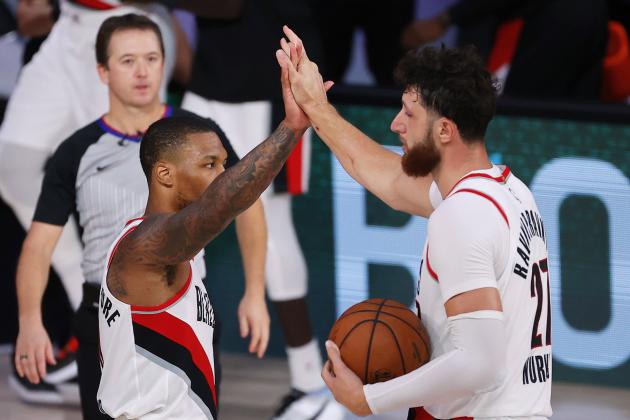 Portland Trail Blazers' Damian Lillard, left, and Jusuf Nurkic celebrate the team's win over the Philadelphia 76ers in an NBA basketball game Sunday, Aug. 9, 2020, in Lake Buena Vista, Fla. (Kevin C. Cox/Pool Photo via AP)