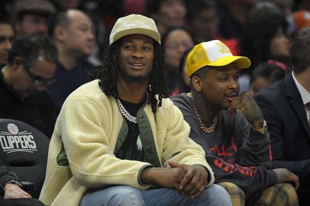 Los Angeles Rams running back Todd Gurley, left, watches along with rapper YG during the first half of an NBA basketball game between the Los Angeles Clippers and the Detroit Pistons Thursday, Jan. 2, 2020, in Los Angeles. (AP Photo/Mark J. Terrill)