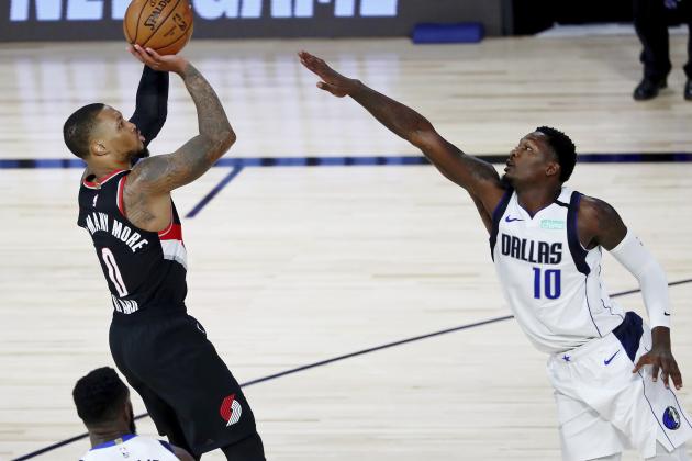 Portland Trail Blazers guard Damian Lillard (0) shoots as Dallas Mavericks forward Dorian Finney-Smith (10) attempts to block during the second half of an NBA basketball game Tuesday, Aug. 11, 2020, in Lake Buena Vista, Fla. (Kim Klement/Pool Photo via AP)