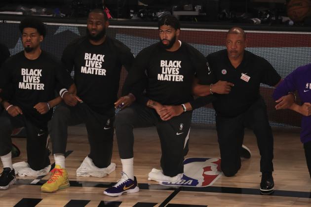 Los Angeles Lakers' LeBron James, second from left, wears a Black Lives Matter shirt and kneels with teammates during the national anthem prior to an NBA basketball game against the Los Angeles Clippers, Thursday, July 30, 2020, in Lake Buena Vista, Fla. (Mike Ehrmann/Pool Photo via AP)