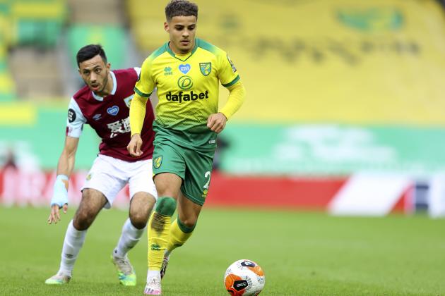 Norwich City's Max Aarons, front, runs for the ball with Burnley's Dwight McNeil during the English Premier League soccer match between Norwich City and Burnley at Carrow Road Stadium in Norwich, England, Saturday, July 18, 2020. (Julian Finney/Pool via AP)