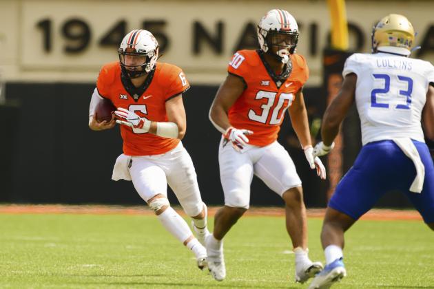 Tulsa linebacker Zaven Collins (23) watches as Oklahoma State quarterback Ethan Bullock (6) runs from behind running back Chuba Hubbard (30) in the second half of an NCAA college football game Saturday, Sept. 19, 2020, in Stillwater, Okla. (AP Photo/Brody Schmidt)