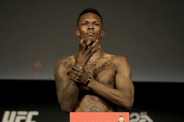 Israel Adesanya gestures while atop a scale during weigh-ins ahead of his mixed martial arts middleweight bout against Derek Brunson at UFC 230, Friday, Nov. 2, 2018, at Madison Square Garden in New York. (AP Photo/Julio Cortez)