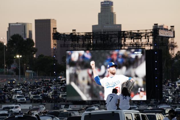 Baseball fans sit in their cars outside Dodger Stadium and watch the television broadcast of Game 6 of the World Series between the Los Angeles Dodgers and the Tampa Bay Rays on Tuesday, Oct. 27, 2020, in Los Angeles. (AP Photo/Ashley Landis)
