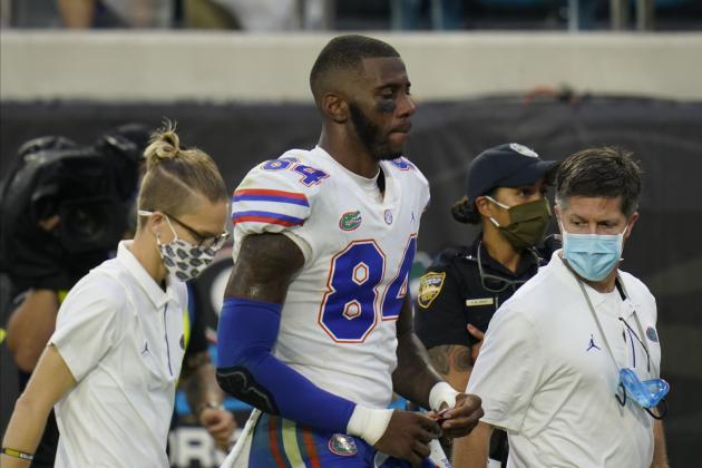 Florida tight end Kyle Pitts, center, is escorted off the field after he was injured during the first half of an NCAA college football game against Georgia, Saturday, Nov. 7, 2020, in Jacksonville, Fla. (AP Photo/John Raoux)