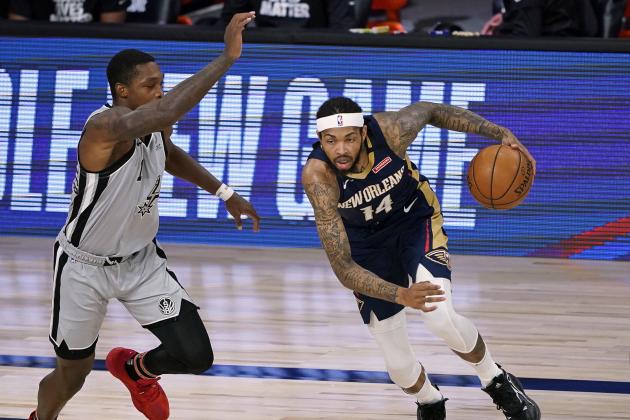 New Orleans Pelicans forward Brandon Ingram, right, drives around San Antonio Spurs guard Lonnie Walker IV, left, during the first half of an NBA basketball game, Sunday, Aug. 9, 2020, in Lake Buena Vista, Fla. (AP Photo/Ashley Landis, Pool)