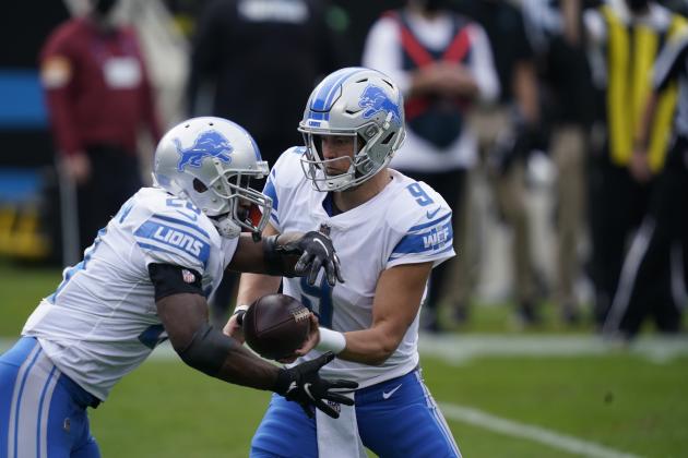 Detroit Lions quarterback Matthew Stafford (9) hands off to running back Adrian Peterson (28) during the first half of an NFL football game against the Carolina Panthers Sunday, Nov. 22, 2020, in Charlotte, N.C. (AP Photo/Gerry Broome)