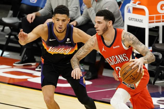 New Orleans Pelicans guard Lonzo Ball (2) drives on Phoenix Suns guard Devin Booker during the first half of an NBA basketball game, Tuesday, Dec. 29, 2020, in Phoenix. (AP Photo/Rick Scuteri)