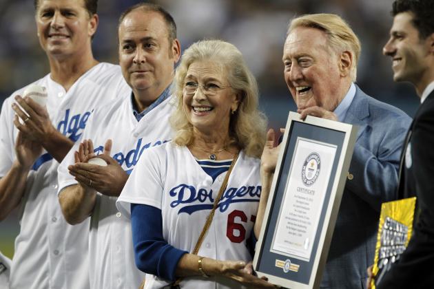 Los Angeles Dodgers broadcaster Vin Scully, second from right, is honored, with his wife Sandi Scully, and sons Kevin and Todd Scully, far left, before a baseball game against the Arizona Diamondbacks in Los Angeles, Wednesday, Sept. 23, 2015. Vin Scully was given a Guinness World Records certificate for the longest career as a sports broadcaster for a single team. (AP Photo/Alex Gallardo)