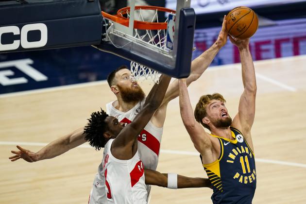 Indiana Pacers forward Domantas Sabonis (11) goes up for a rebound with Toronto Raptors forward OG Anunoby (3) and center Aron Baynes (46) during the first half of an NBA basketball game in Indianapolis, Monday, Jan. 25, 2021. (AP Photo/Michael Conroy)