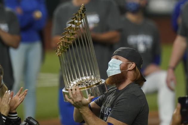 FILE  - In this Tuesday, Oct. 27, 2020, file photo, Los Angeles Dodgers third baseman Justin Turner celebrates with the trophy after defeating the Tampa Bay Rays 3-1 to win the baseball World Series in Game 6 in Arlington, Texas. Baseball nearly made it through its version of playoff bubbles unscathed; two innings before the World Series ended, Justin Turner of the now-champion Los Angeles Dodgers Turner was pulled from the game after MLB was notified that he had tested positive for COVID-19. (AP Photo/Eric Gay, File)