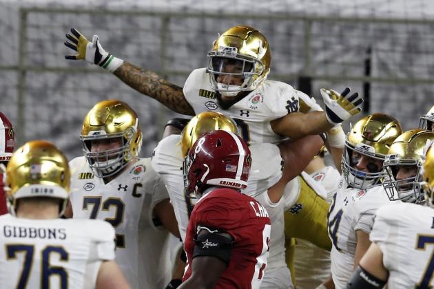 Notre Dame running back Kyren Williams, top, is lifted by offensive lineman Landon Dickerson (69) after Williams' touchdown run as Alabama linebacker Christian Harris (8) looks on in the first half of the Rose Bowl NCAA college football game in Arlington, Texas, Friday, Jan. 1, 2021. (AP Photo/Roger Steinman) Notre Dame running back Kyren Williams, top, is lifted by offensive lineman Landon Dickerson (69) after Williams' touchdown run as Alabama linebacker Christian Harris (8) looks on in the first half of the Rose Bowl NCAA college football game in Arlington, Texas, Friday, Jan. 1, 2021. (AP Photo/Roger Steinman)