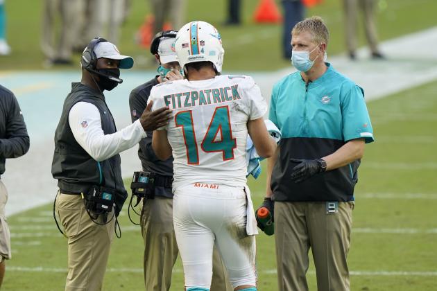 Miami Dolphins quarterback Ryan Fitzpatrick (14) talks to head coach Brian Flores during the first half of an NFL football game against the New York Jets, Sunday, Oct. 18, 2020, in Miami Gardens, Fla. (AP Photo/Wilfredo Lee)