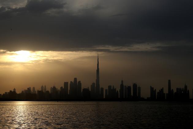Sun sets behind the city skyline and the world tallest tower, Burj Khalifa in Dubai, United Arab Emirates, Friday, Feb. 19, 2021. (AP Photo/Kamran Jebreili)