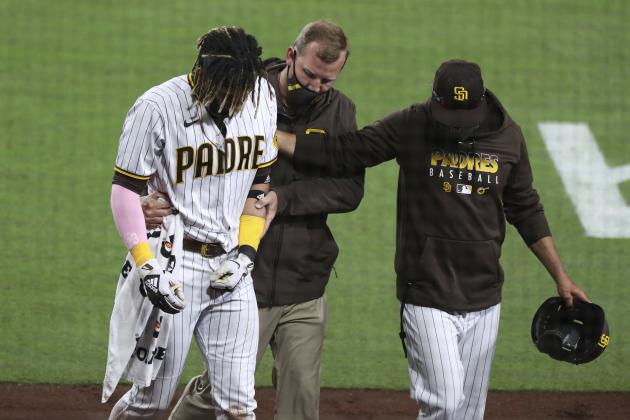 San Diego Padres manager Jayce Tingler, right, and a trainer help Fernando Tatis Jr, left, off the field after Tatis hurt his shoulder while swinging at a pitch in the third inning of a baseball game against the San Francisco Giants, Monday, April 5, 2021, in San Diego. (AP Photo/Derrick Tuskan)