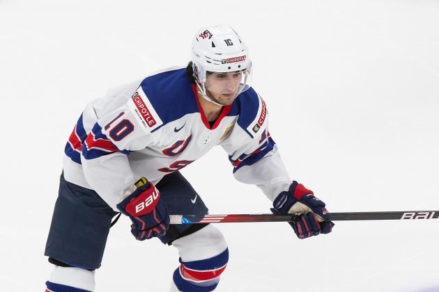 Latvia's Andris Dzerins, left, challenges for the puck with Matty Beniers of the US during the Ice Hockey World Championship group B match between United States and Latvia at the Arena in Riga, Latvia, Thursday, May 27, 2021. (AP Photo/Sergei Grits)