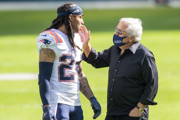 New England Patriots owner Robert Kraft wears a mask on the field as he talks with New England Patriots cornerback Stephon Gilmore (24) before the Patriots take on the Miami Dolphins during an NFL football game, Sunday, Dec. 20, 2020, in Miami Gardens, Fla. (AP Photo/Doug Murray)