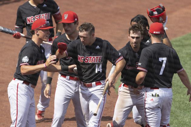 North Carolina State's Jonny Butler (14), center, celebrates with teammates, from left to right, DeAngelo Giles, Eddie Eisert, Austin Murr, Jose Torres and Danny Carnazzo (7) after scoring a run against Stanford in the ninth inning in the opening baseball game of the College World Series, Saturday, June 19, 2021, at TD Ameritrade Park in Omaha, Neb. (AP Photo/Rebecca S. Gratz)