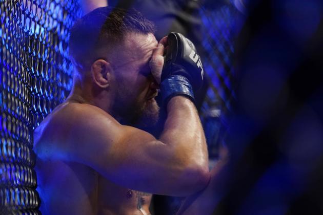 Conor McGregor sits on the mat after an injury during his lightweight mixed martial arts bout with Dustin Poirier at UFC 264 on Saturday, July 10, 2021, in Las Vegas. (AP Photo/John Locher)