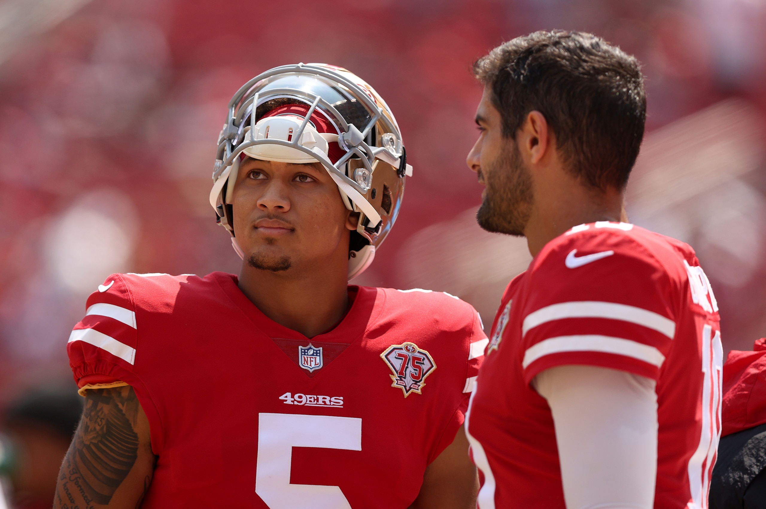 SANTA CLARA, CALIFORNIA - AUGUST 29: Jimmy Garoppolo #10 and Trey Lance #5 of the San Francisco 49ers talk to each other on the sidelines before their preseason game against the Las Vegas Raiders at Levi's Stadium on August 29, 2021 in Santa Clara, California. (Photo by Ezra Shaw/Getty Images)