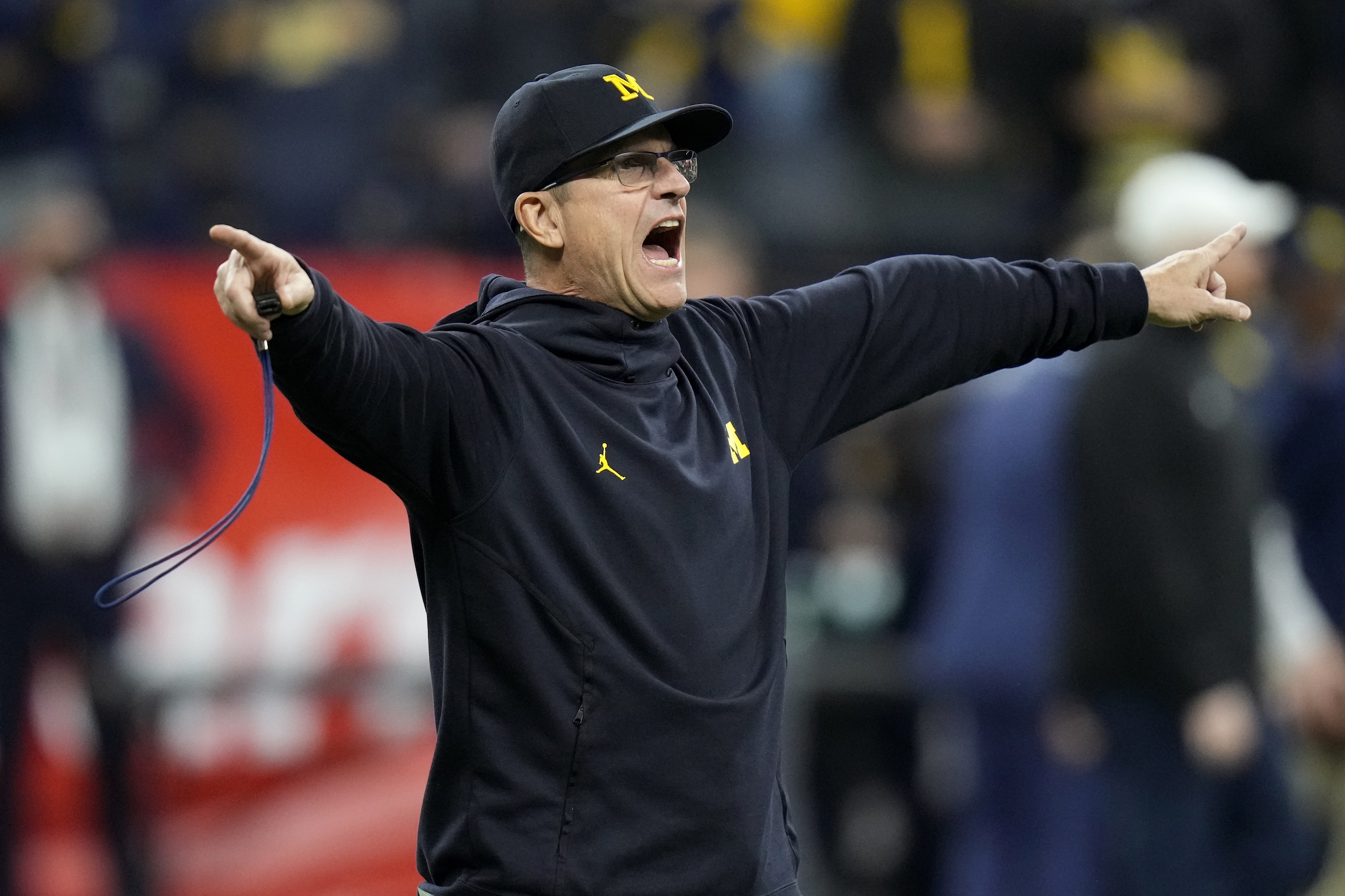 Michigan head coach Jim Harbaugh directs his team during warmups before the Big Ten championship NCAA college football game against Iowa, Saturday, Dec. 4, 2021, in Indianapolis. (AP Photo/AJ Mast) Michigan head coach Jim Harbaugh directs his team during warmups before the Big Ten championship NCAA college football game against Iowa, Saturday, Dec. 4, 2021, in Indianapolis. (AP Photo/AJ Mast)