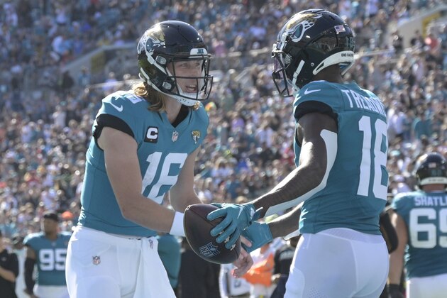 Jacksonville Jaguars quarterback Trevor Lawrence, left, and Jacksonville Jaguars wide receiver Laquon Treadwell, right, celebrate after scoring a touchdown against the Indianapolis Colts during the first half of an NFL football game, Sunday, Jan. 9, 2022, in Jacksonville, Fla. (AP Photo/Phelan M. Ebenhack)