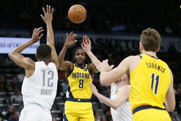 Indiana Pacers forward Justin Holiday (8) passes to center Domantas Sabonis (11) past Oklahoma City Thunder forward Mamadi Diakite (12) in the first half of an NBA basketball game Friday, Jan. 28, 2022, in Oklahoma City. (AP Photo/Nate Billings)