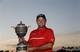 Patrick Reed holding the 2014 WGC-Cadillac trophy.
