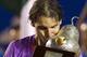 Rafael Nadal bites down on a golden pear trophy at the 2013 Acapulco Open.