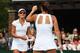 Jarmila Gajdosova, with her back turned, talks with her doubles partner during a match at Wimbledon, 2014.