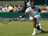 Gael Monfils stretches to make a play during a Wimbledon match.