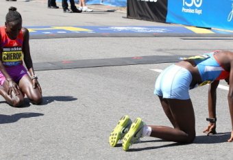 Sharon Cherup (1st) and Jemima Sumgong (2nd) crouch to their knees at the end of the 2012 Boston Marathon