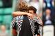 Alexander Zverev, with his back to the camera, gets a hug from Dominic Thiem during the 2016 French Open.
