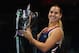 Dominika Cibulkova shows off the trophy she won at the 2016 WTA Tour Finals in Singapore.