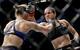 Amanda Nunes (right) punches Ronda Rousey.